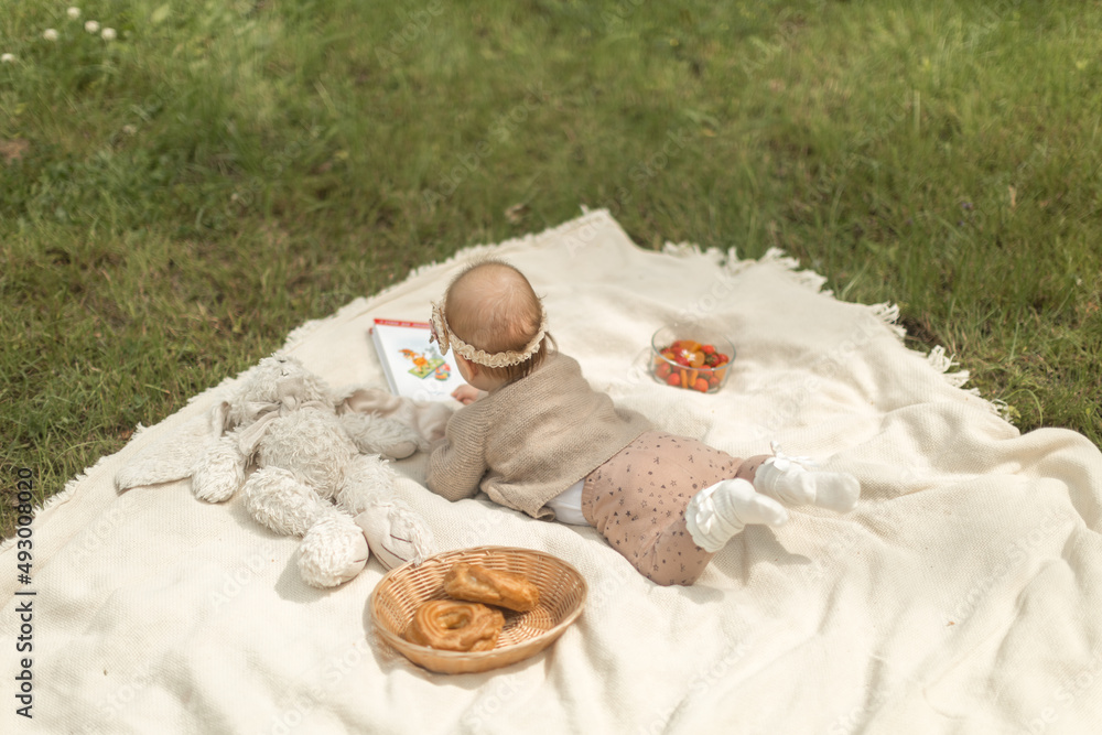 .A CHILD AT A SUMMER PINCIC, A CHILD LIES ON A PLAQUE