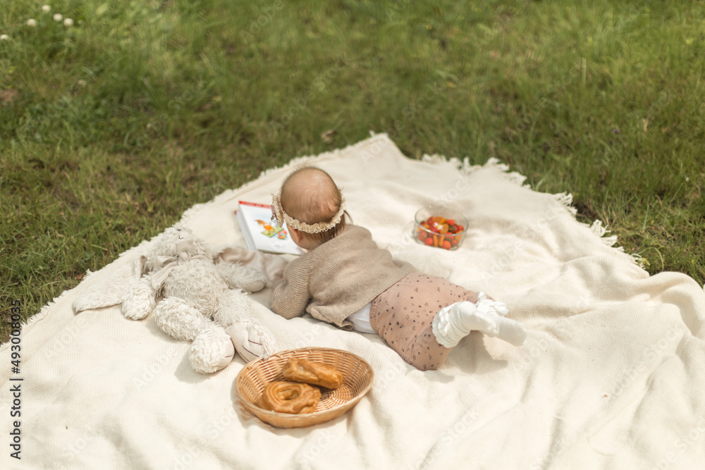 .A CHILD AT A SUMMER PINCIC, A CHILD LIES ON A PLAQUE