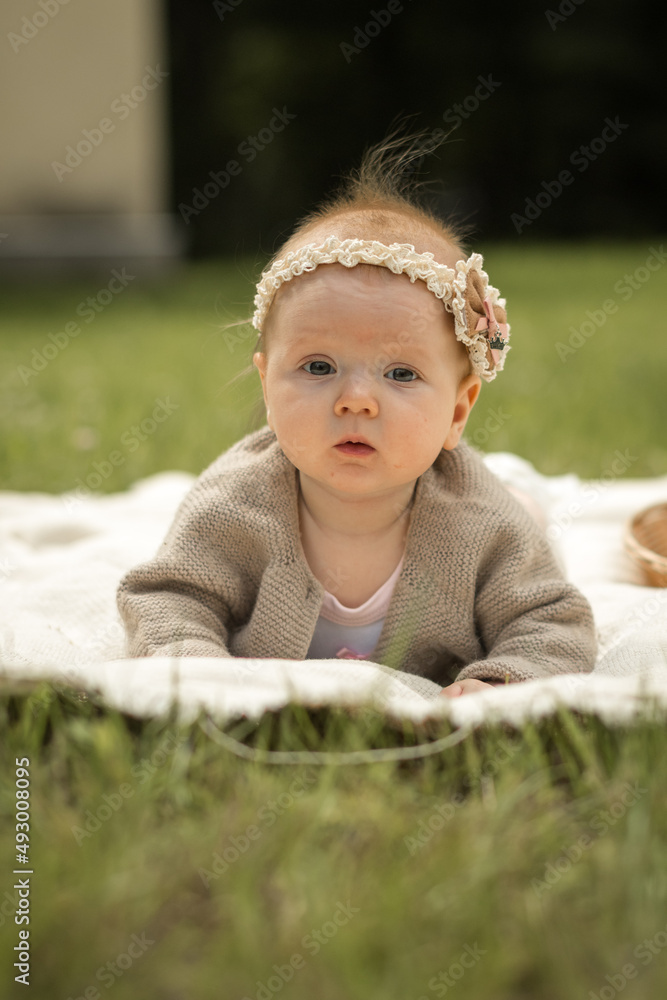 baby girl lies on a plaid, summer picnic for children