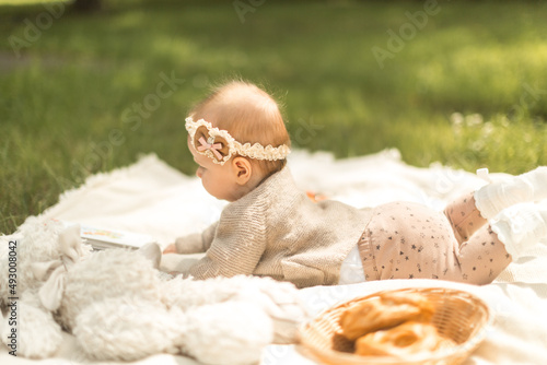 baby girl lies on a plaid, summer picnic for children