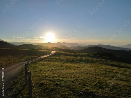Sunset from the top of the green meadows of a mountain.
