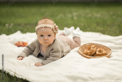 baby girl lies on a plaid, summer picnic for children