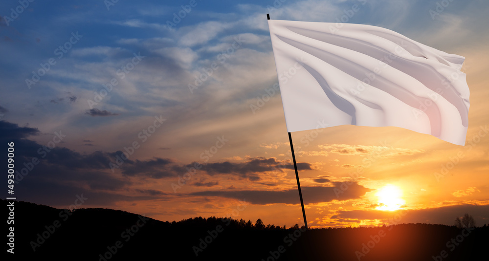 Foto de White flag waving in the wind on flagpole against the sunset ...