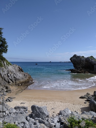 Small golden sandy beach between rocks on the Atlantic coast. Vertical view.
