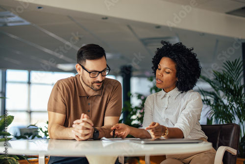 The male boss has a meeting with his female African female, at t