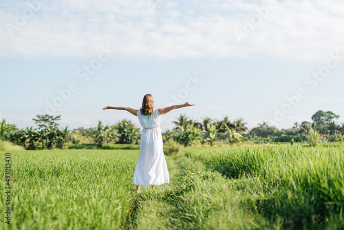 Pregnant woman going at the field with green grass and dance with happy face. Sunshine summer vibes