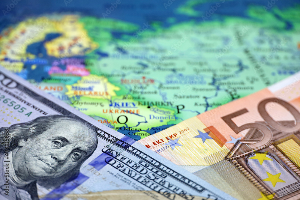 US dollars and Euro banknotes on map of Russia and Ukraine. Concept of USA and european support of Kiev