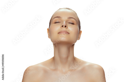 Portrait of young tender woman with closed eyes posing isolated over white studio background