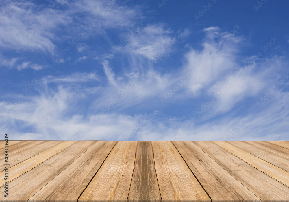 Empty wooden table with cloudy sky on background