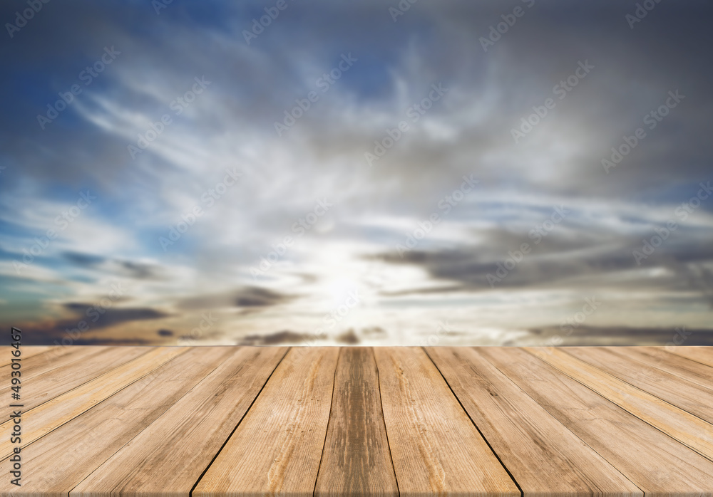 Empty wooden table with cloudy sky on background