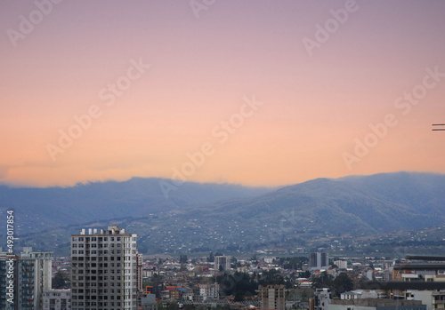 view of the city and mountains at sunset. © velimir