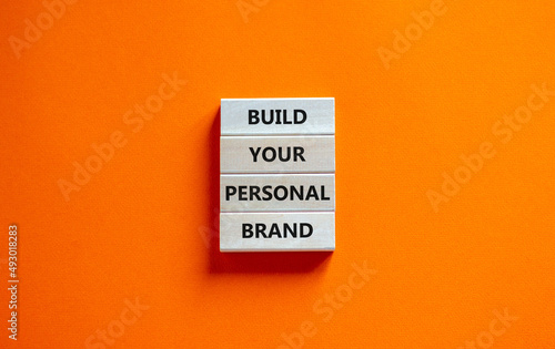 Build your personal brand symbol. Concept words Build your personal brand on wooden blocks. Beautiful orange table orange background. Build your personal brand business concept. Copy space. photo