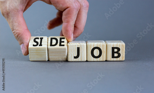 Side job symbol. Businessman turns wooden cubes and changes concept words Job to Side job. Beautiful grey table grey background, copy space. Business side job concept.