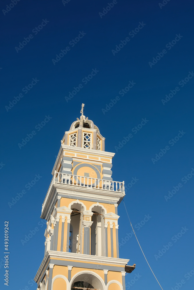 A beautiful and colorful Greek Orthodox Church and a blue sky in Fira Santorini Greece