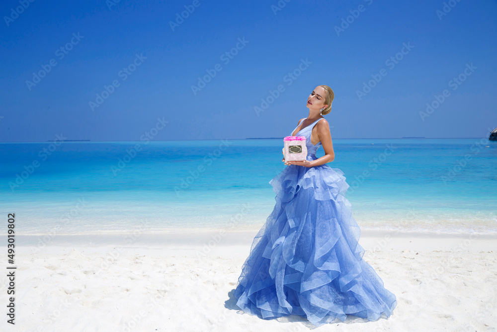 Summer fashion. Elegant fashion model. Glamour, stylish female model in elegant long gown dress on the Maldives beach. Travel model. Elegance. Bride on Maldives - concept. Bridal fashion.Classy woman. Summer fashion. Elegant fashion model. Glamour, stylish female model in elegant long gown dress on the Maldives beach. Travel model. Elegance. Bride on Maldives - concept. Bridal fashion.Classy woman.