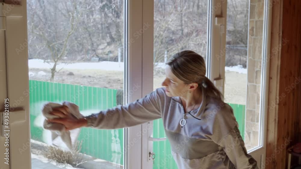 A woman is cleaning the house, she washes the windows. A woman is cleaning the house, she washes the windows.