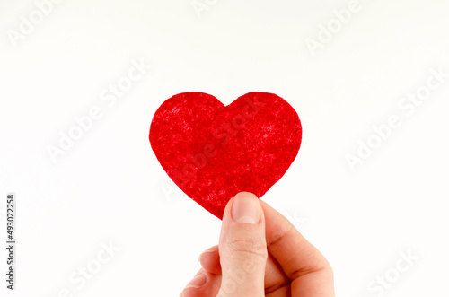 Small red heart in female hand, world heart day, world donor day.