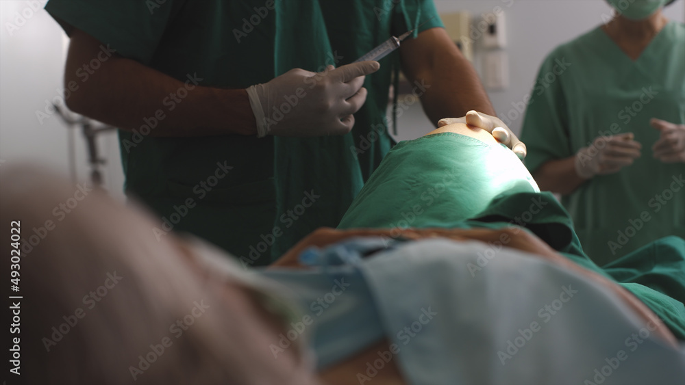 Surgeon diagnose a senior Asian adult woman knee problem before a replacement surgical procedure in the operating room. Concept hospital care Surgeon diagnose a senior Asian adult woman knee problem before a replacement surgical procedure in the operating room. Concept hospital care