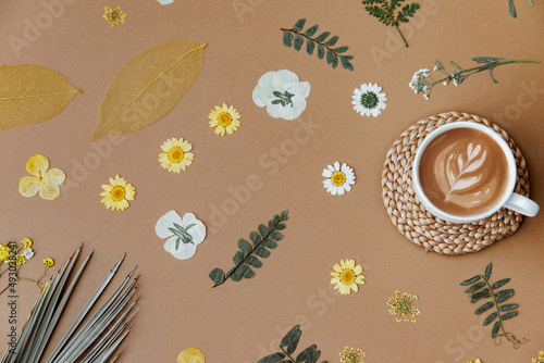 Flat lay dry flowers and coffee cup on beige background. Minimal composition. Blogger composition. Modern aesthetic. Neutral earth tones. Holiday morning breakfast photo