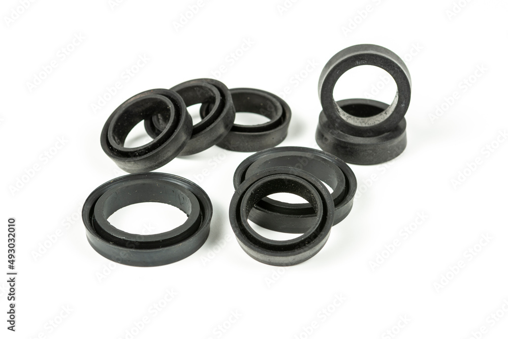 Fototapeta premium A rubber ring - a gasket, an oil seal for repairing a car brake caliper on a plane. Set of spare parts for car brake repair. Details on white background, copy space available.