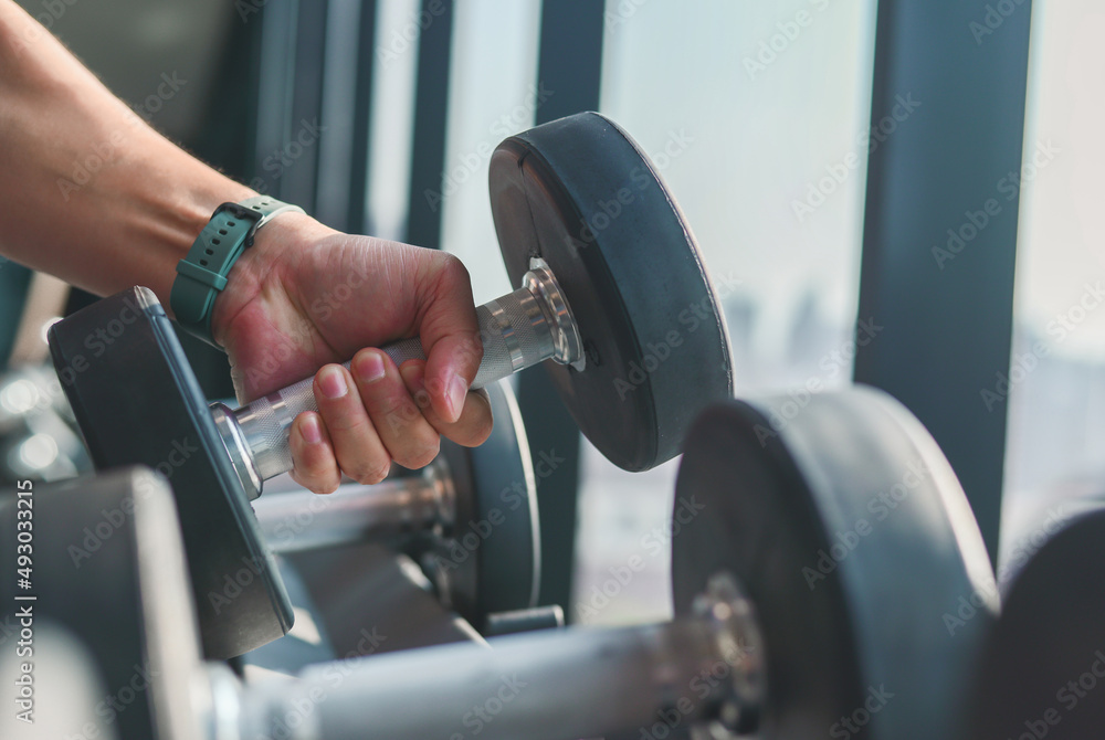 Athlete in the gym training with dumbbells.,Man is engaged with dumbbells on the bench. Hands with dumbbells Athlete in the gym training with dumbbells.,Man is engaged with dumbbells on the bench. Hands with dumbbells