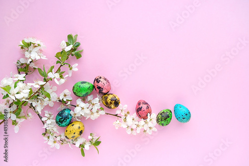 Easter colorful eggs and cherry flowers on pink background. symbol of Easter Christian holiday. spring festive decor. flat lay. copy space