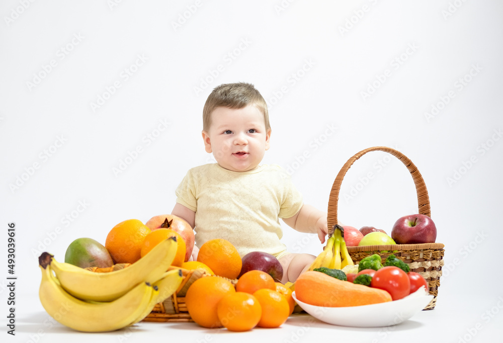Cute baby boy sitting with fruits and vegetables isolated on white background healthy food feed baby Cute baby boy sitting with fruits and vegetables isolated on white background healthy food feed baby