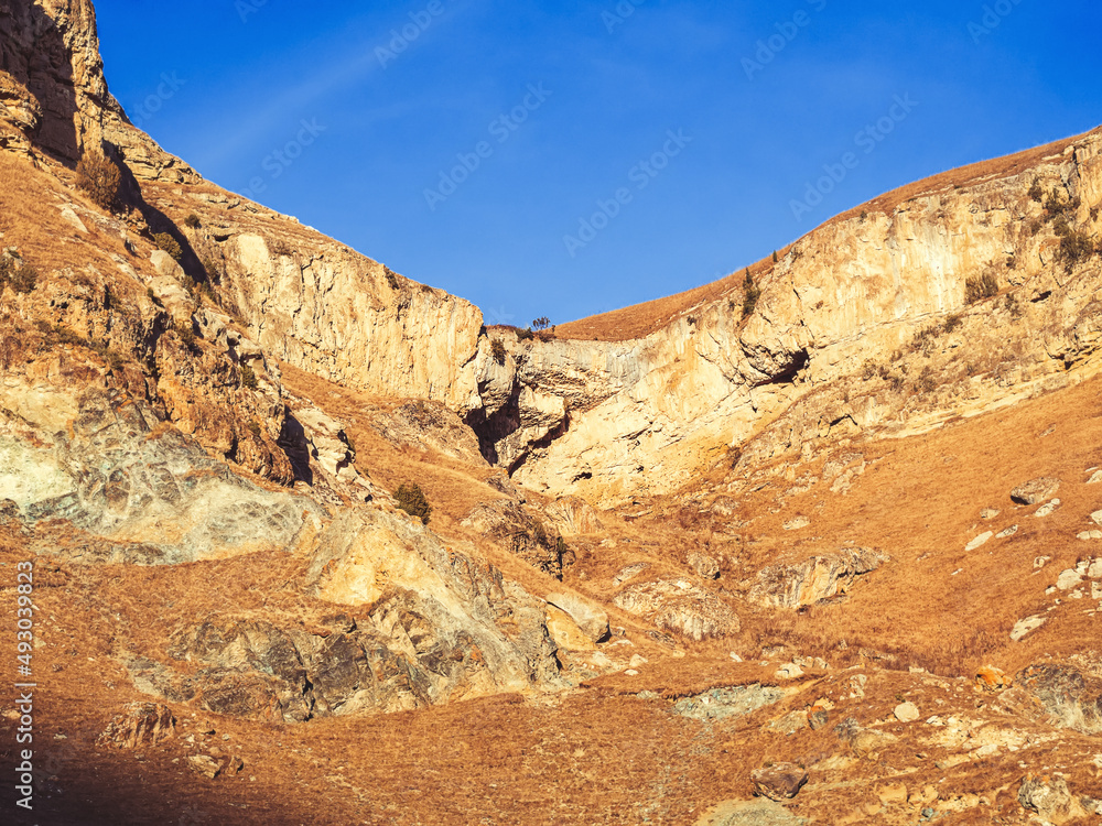 Autumn rocky plateau illuminated by the sun against the blue sky. Country mountain beauty of the Caucasus. Valley of the Narzans