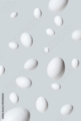Flying or levitate Easter eggs on bright gray background. Minimal abstract creative concept. Visual Trendy inspiration.
