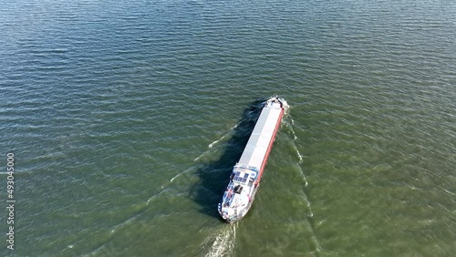 Freight ship barge sailing on the Ketelmeer and IJsselmeer close to the Ketelbrug bridge in Flevoland, The Netherlands. photo