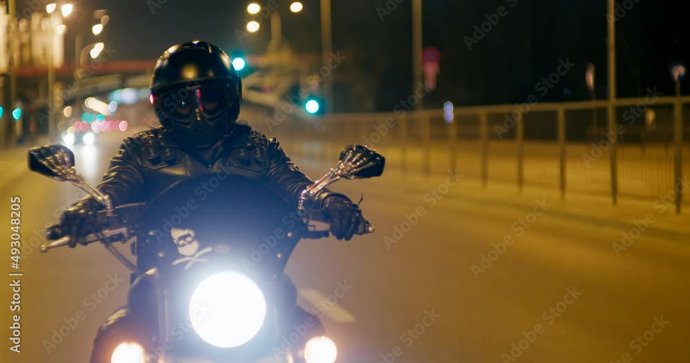 Biker is Riding Motorcycle on City roads and streets at late night. Motorcyclist drives Motorbike in evening with lights. Close up to wheel with copy space on asphalt. 4K medium tracking shot Biker is Riding Motorcycle on City roads and streets at late night. Motorcyclist drives Motorbike in evening with lights. Close up to wheel with copy space on asphalt. 4K medium tracking shot