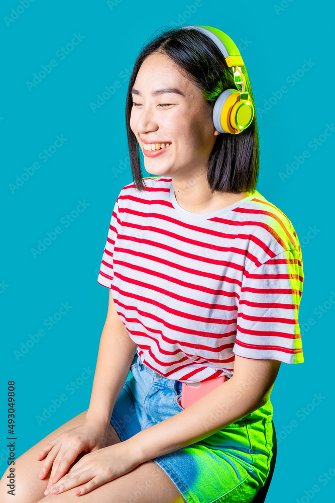 Φωτογραφία Young asiatic woman wearing wireless headphones listening music