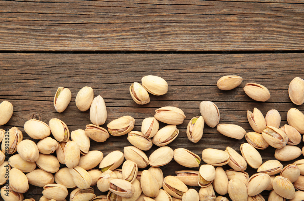 Pile of Pistachios on the grey wooden background. Pile of Pistachios on the grey wooden background.