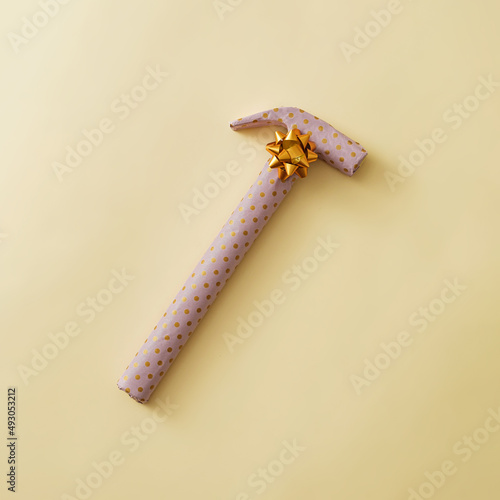 Gift wrapped hammer in yellow polka dot paper photo