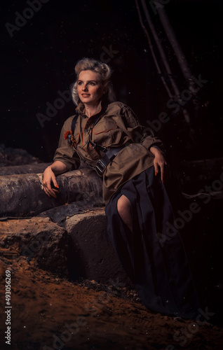 a girl in military clothes from 1945 sits in the dark