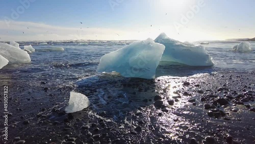 Beautiful sunset over famous Diamond beach, Iceland. This sand lava beach is full of many giant ice gems, placed near glacier lagoon Jokulsarlon Ice rock with black sand beach in southeast Iceland photo