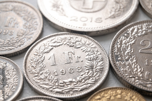 Swiss franc coins on white surface. Value of the Swiss Franc and exchange rate trend. 