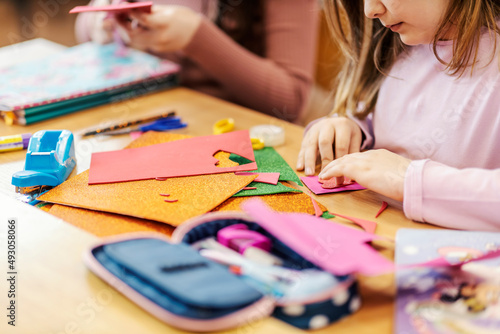 Hands of girls making art project on arts and crafts at school. photo