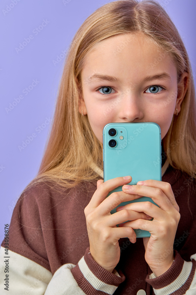 american little kid girl with smartphone dressed casually in shirt over purple background, being deeply surprised, stares at camera, reads shocking news on website, Omg, its horrible american little kid girl with smartphone dressed casually in shirt over purple background, being deeply surprised, stares at camera, reads shocking news on website, Omg, its horrible