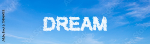 Dream word made of clouds on blue sky background