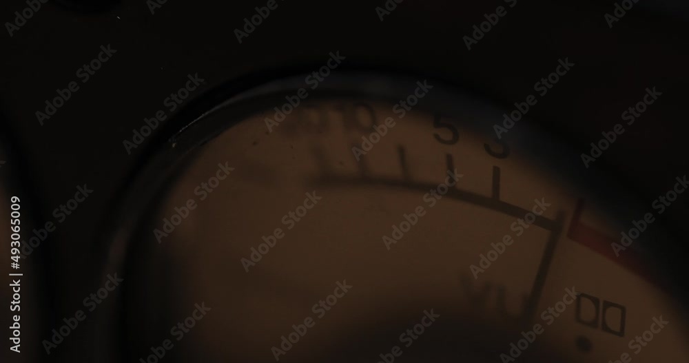 arrow of the analog sound level indicator twitches in a retro sound recording studio device in the dark. closeup. Macro arrow of the analog sound level indicator twitches in a retro sound recording studio device in the dark. closeup. Macro