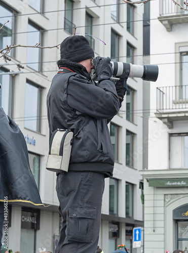 Fotograf mit Teleobjektiv beobachtet Fasnachtsumzug, Fasnacht in Luzern, Schweiz