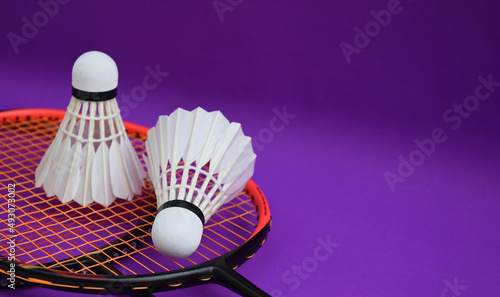 White cream badminton shuttlecocks, badminton rackets on purple floor of indoor badminton court, soft and selective focus on shuttlecock, concept for badminton sport lovers around the world © Sophon_Nawit