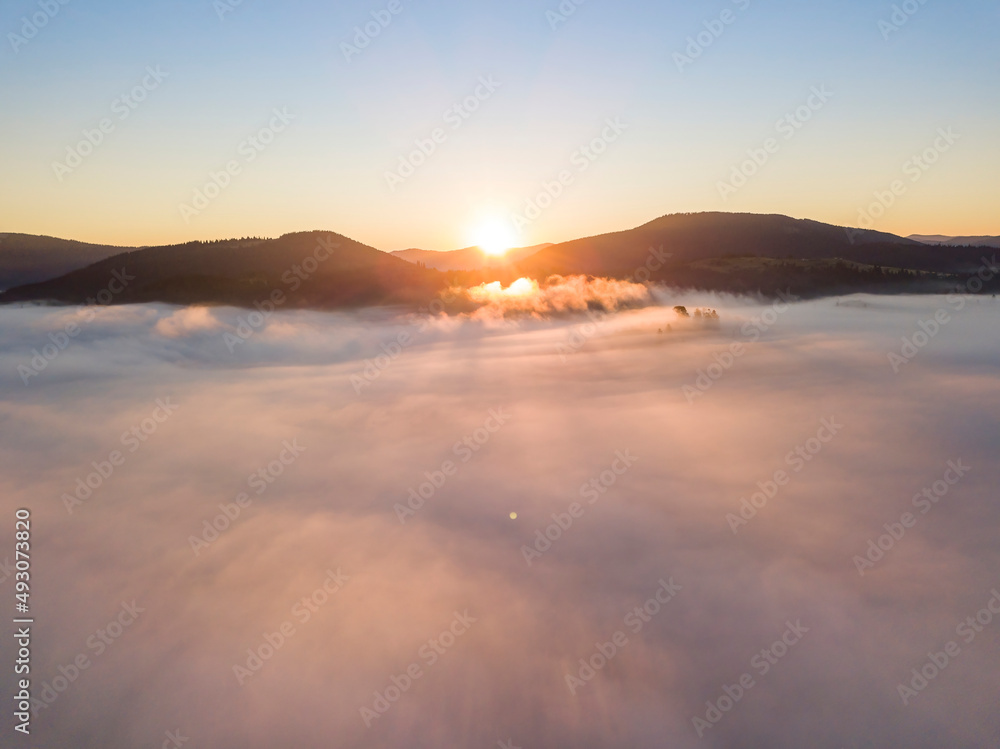 Sunrise over the fog in the Ukrainian Carpathians. Aerial drone view.