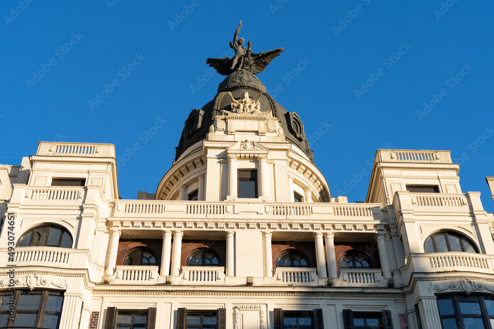 Historic building with sculpture on top designed in 1928 in Bilbao city