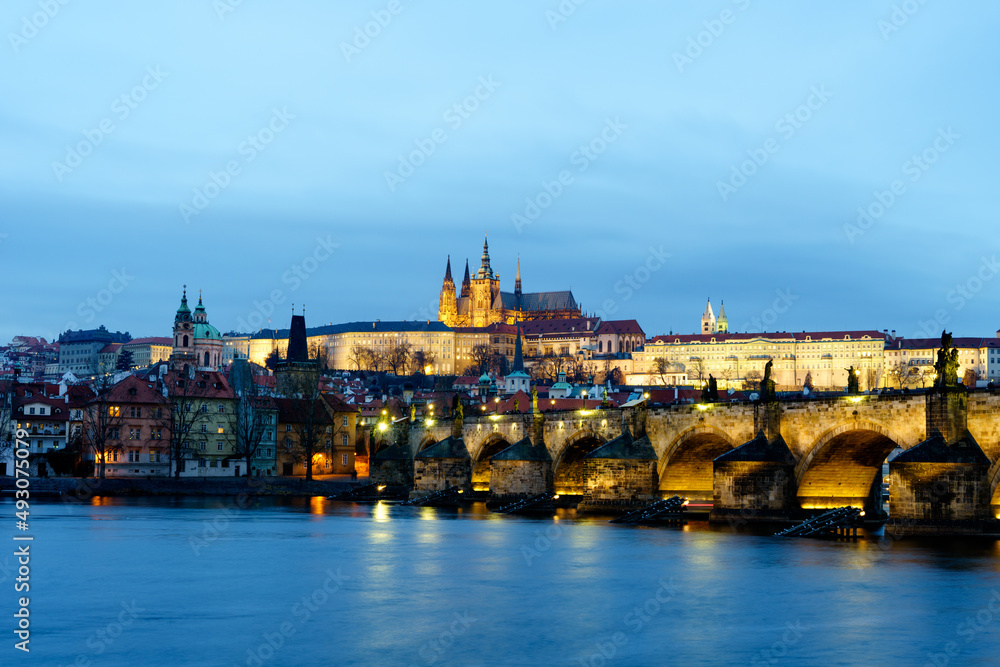 Blick auf die Karlsbrücke und die Prager Burg in Prag, Tschechien, in der Abenddämmerung; Prag am Abend in der Dämmerung