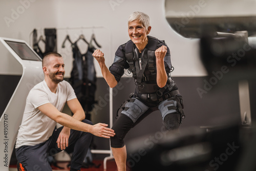Tableau sur toile Senior Woman Doing EMS Workout With Coach In The Gym