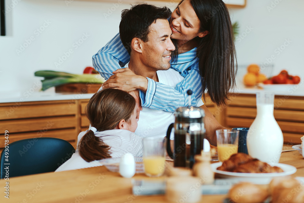 Woman kissing her husband during breakfast Woman kissing her husband during breakfast