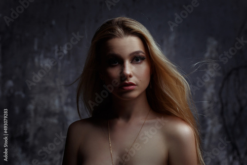 Beautiful blonde girl on a dark background.