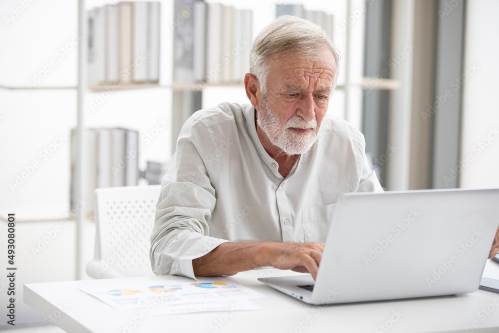 senior businessman using laptop computer and serious at work senior businessman using laptop computer and serious at work